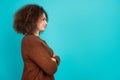 Photo portrait of young woman profile crossed hands empty space dressed stylish brown clothes isolated on aquamarine