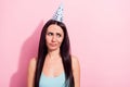 Photo portrait of young woman unhappy unsure having doubt wearing birthday cone at party isolated on pastel pink color