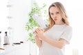 Photo portrait young woman in white outfit blonde keeping hair dryer with pouted lips