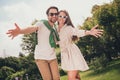 Photo portriat young couple smiling with opened hands on meeting with friends wearing sunglass