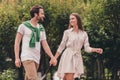 Photo portriat young couple smiling walking in green park holding hands on date having nice mood