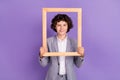 Photo of positive blogger schoolkid hold wooden frame make portrait wear grey suit isolated violet color background Royalty Free Stock Photo