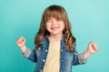 Photo of positive carefree winner little girl celebrate victory wear jeans jacket aquamarine color background