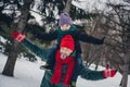 Photo of positive cheerful father son piggyback raise hands enjoy pastime walk snowy woods outside Royalty Free Stock Photo