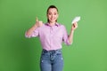 Photo of positive cheerful girl hold hand paper plane show thumb up sign wear lilac violet denim jeans isolated over Royalty Free Stock Photo