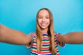 Photo of positive cheerful girl with straight hairdo dressed striped t-shirt smiling doing selfie isolated on blue color Royalty Free Stock Photo