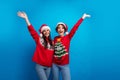 Photo of positive cheerful santa claus helpers elf girls raise hands up advertise new year ads isolated blue color