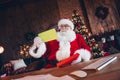 Photo of positive cheerful santa claus wear red costume getting many greeting postcards indoors north pole office Royalty Free Stock Photo