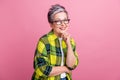 Photo of positive cheerful woman with short hair wear checkered shirt hold arm on chin think business isolated on pink