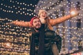 Photo of positive couple having fun christmas x-mas around evening outside illumination boyfriend piggyback girlfriend