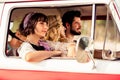 Photo of positive cute funny hippie people company smiling riding retro van outside seaside beach