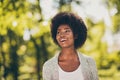 Photo of positive dark skin lady look on city summer park trees wear knitted sweater Royalty Free Stock Photo