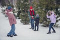 Photo of positive funky little child wife husband dressed coats having fun playing snow balls together outdoors urban Royalty Free Stock Photo