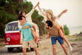 Photo of positive funny hippie people company having fun together riding retro van outside seaside beach