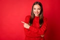 Photo of positive girl point finger empty space for adverts promo wear pullover isolated on bright red color background