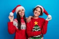 Photo of positive girls in santa costume advertise traditional holly jolly gifts sale isolated blue color background