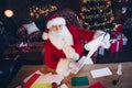 Photo of positive good mood santa claus dressed red costume preparing new year gifts list indoors north pole home Royalty Free Stock Photo