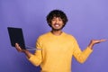 Photo of positive handsome funny man wear trendy yellow clothes demonstrate empty space isolated on purple color