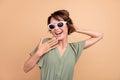 Photo of positive happy amazed young woman hand face wear sunglass news  on beige color background Royalty Free Stock Photo