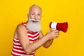 Photo of positive happy grandfather wearing striped swimsuit annonce information about summer sale isolated on yellow