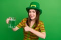 Photo of positive lady in leprechaun suit advertise thumb up reaction to patrick ale lager glass isolated green color Royalty Free Stock Photo