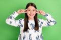 Photo of positive lovely schoolkid girl make v-sign show on face isolated over green color background