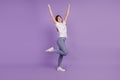 Photo of positive lucky girl raise fists win isolated over purple background