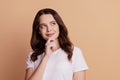 Photo of positive minded clever lady look copyspace finger chin posing on beige background