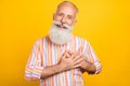 Photo of positive nice glad grateful pensioner hands heart wear striped shirt isolated yellow color background