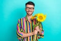 Photo of positive nice person beaming smile hands hold bunch sunflowers isolated on aquamarine color background