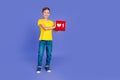 Photo of positive pretty boy blogger wear trendy yellow clothes hands showing red card heart like on violet