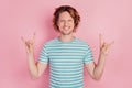 Photo of positive rocker man show horns gesture wear casual blue striped t-shirt on pink background Royalty Free Stock Photo