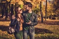 Photo of positive romantic couple talk walk in autumn september town park wear backpack casual jacket