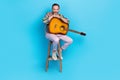 Photo of positive talented eccentric showman host sitting stool preparing concert on blue color background