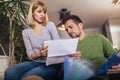 Positive young couple embracing and calculating the bills at home Royalty Free Stock Photo