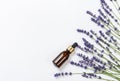 Photo poster with skin care items: a brown glass bottle with oil and lavender flowers and stems on a light background