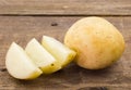 Photo of potato and slices on wood table