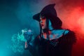 Photo of powerful lady witch cooking potion liquid mystical love ritual on halloween night over neon mist background