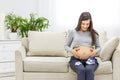 Photo of pregnant woman with little blue male shoes. Royalty Free Stock Photo