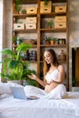 Vertical photo of a pregnant woman sits at home in front of a laptop monitor - online consultation with a doctor or Royalty Free Stock Photo