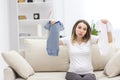 Photo of pregnant woman wearing casual clothes and holding childish clothes in hands. Royalty Free Stock Photo