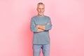 Photo of pretty attractive retired man wear grey shirt arms folded smiling isolated pink color background Royalty Free Stock Photo