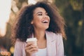 Photo of pretty charming dark skin curly wavy lady drink takeaway hot coffee laughing out laud with friends enjoy