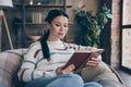 Photo of pretty charming lady sit chair read romantic novel wear striped sweater in comfortable apartment home indoors