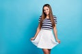 Photo of pretty charming lady traveler hold short wavy skirt good mood long hairstyle toothy smiling wear white striped