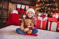 Photo of pretty charming school girl wear print pullover headwear smiling sitting floor hugging bear indoors house home Royalty Free Stock Photo