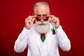 Photo of pretty confident age gentleman wear new year costume arms dark eyewear isolated red color background