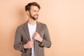 Photo of pretty confident young guy wear jacket smiling looking empty space isolated beige color background