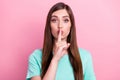 Photo of pretty confident young lady wear teal t-shirt finger lips asking keep silence isolated pink color background