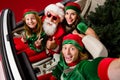 Photo of pretty cute santa claus assistants driving car showing v-sign thumbs up isolated white color background Royalty Free Stock Photo